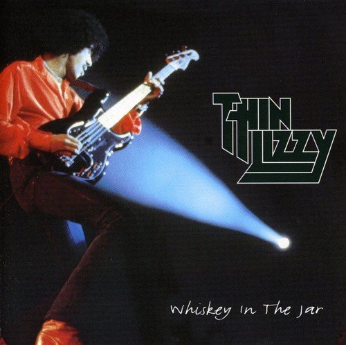 Thin Lizzy album cover: musician with bass guitar, spotlight, and band logo.
