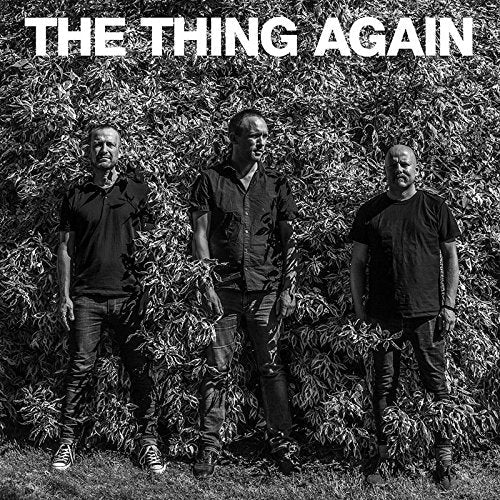 Black and white album cover with three men standing in front of a leafy background.