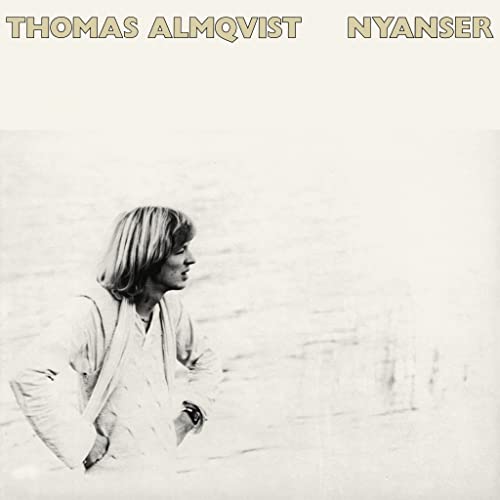Black and white album cover featuring a man looking towards the sea.