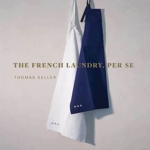 Cookbook cover featuring two aprons, white and navy, with gold text.
