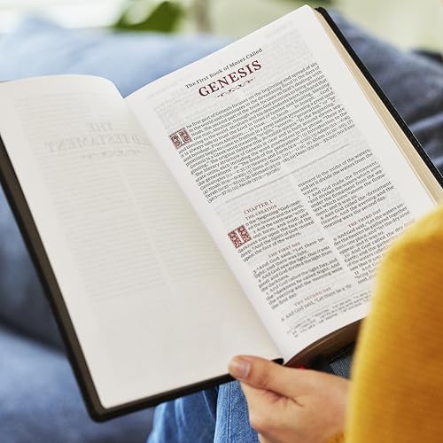 Open purple Bible displaying the Book of Genesis, red lettering visible.