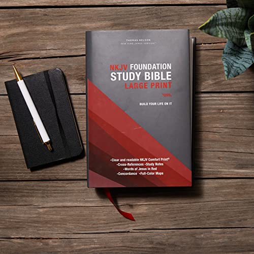 NKJV Foundation Study Bible with a pen and notebook on a wooden surface.