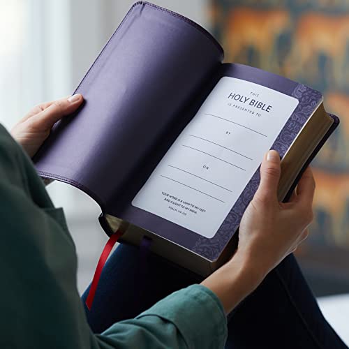 Open purple leathersoft Bible with red ribbon marker and presentation page.