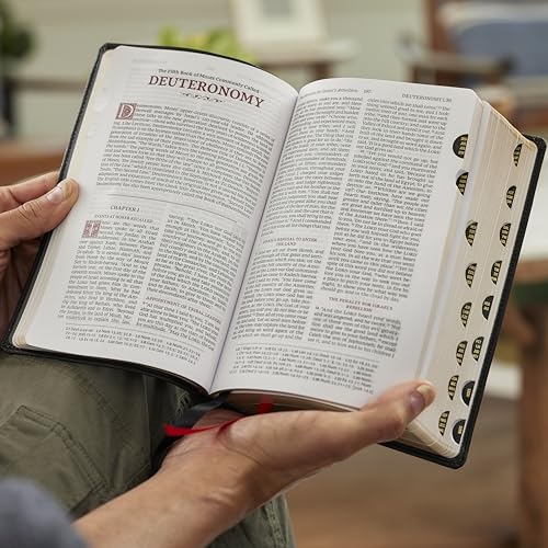 Open purple Bible with thumb indexing, displaying text on two pages.