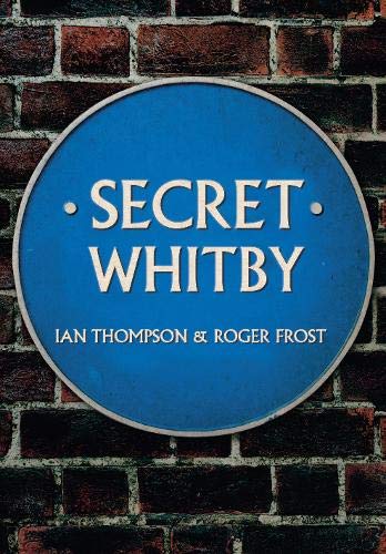 Blue circular plaque reading “Secret Whitby” against a brick wall.