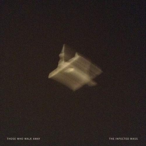 A blurry, pale, geometric shape floats in a dark, grainy background.