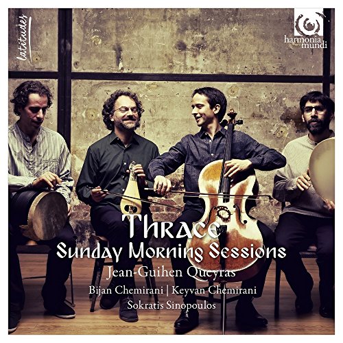 Four musicians playing string and percussion instruments in front of a textured concrete wall.