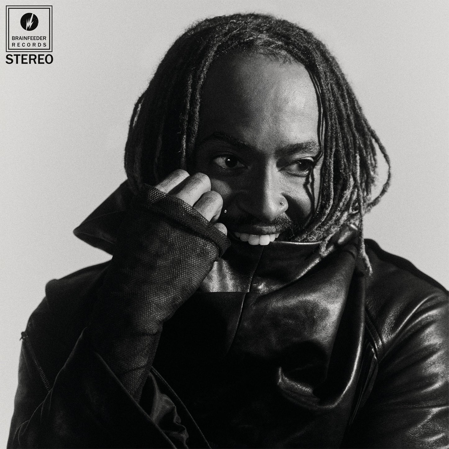 Black and white portrait of Thundercat with dreadlocks, looking at the viewer.