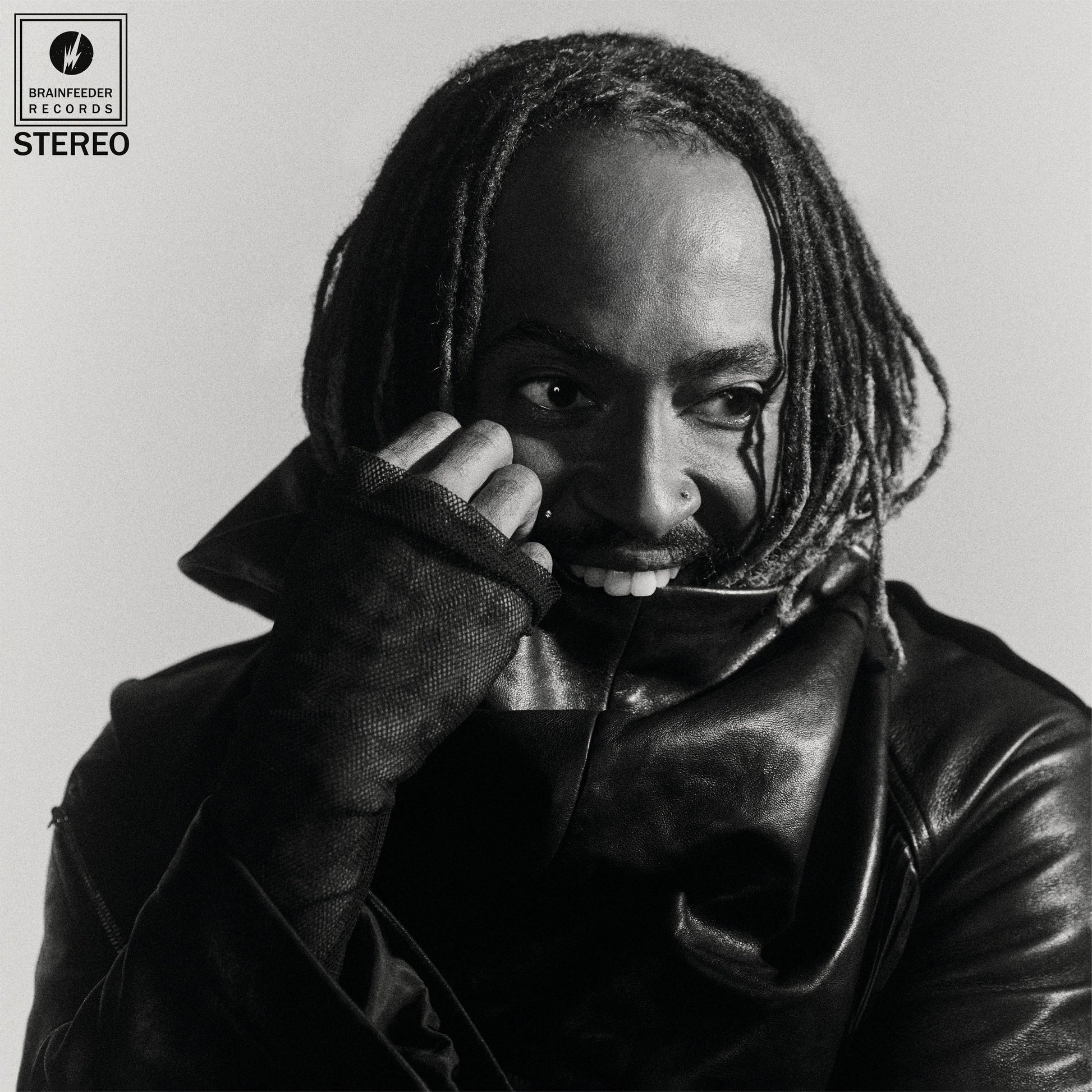 Black and white portrait of Thundercat with dreadlocks, looking at the viewer.