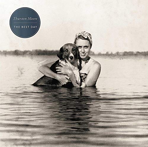 Black and white album cover featuring a woman and dog in water.