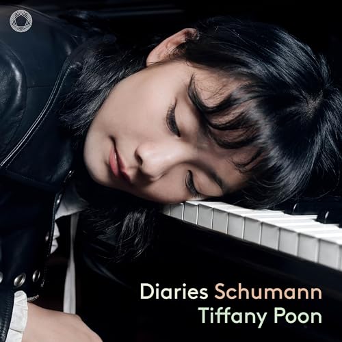 Young pianist Tiffany Poon rests her head on a piano keyboard.