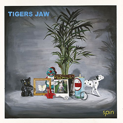 spin" album cover by Tigers Jaw, featuring a still life with toys and plants.