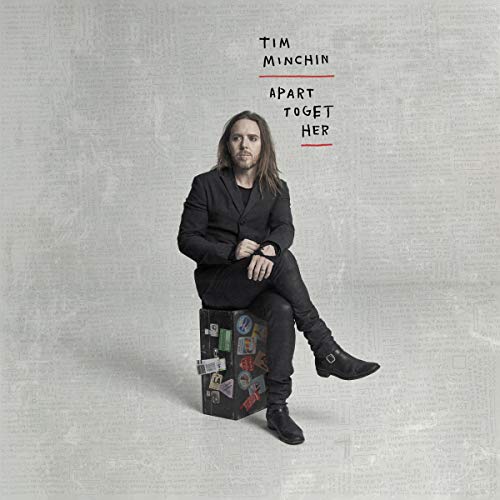 "Album cover featuring Tim Minchin sitting on a box, dressed in black, against a grey background."