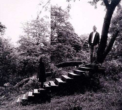 Black and white album cover with figures on stone steps in woods.