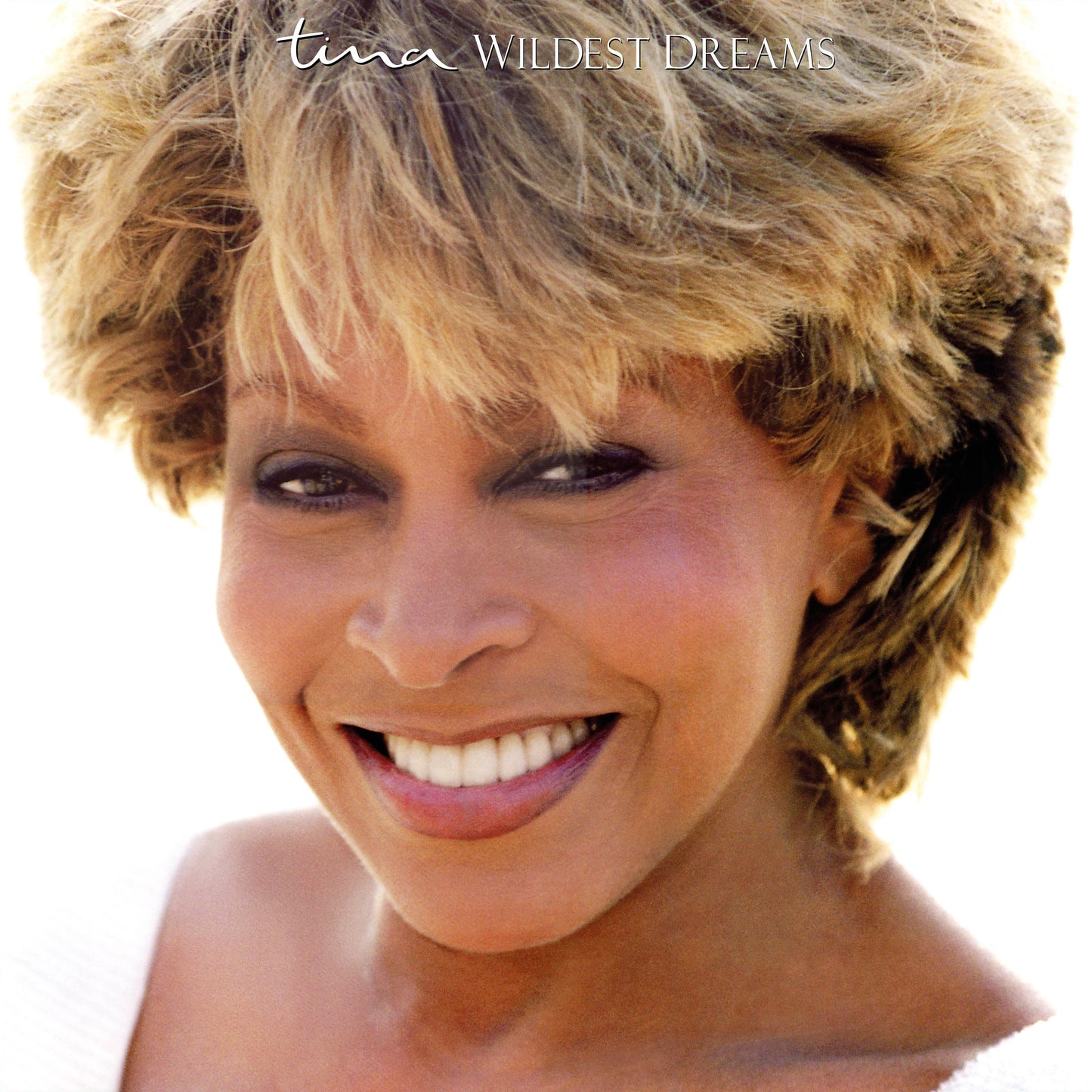 Close-up portrait of Tina Turner smiling with the text Tina Wildest Dreams above her.