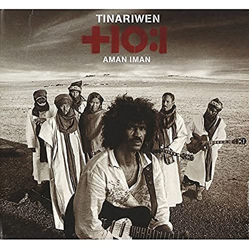 Desert landscape with a group of men in robes and headscarves, one with guitar.