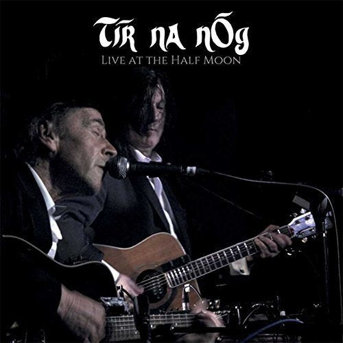 Two musicians playing guitars with microphones on a dark stage.