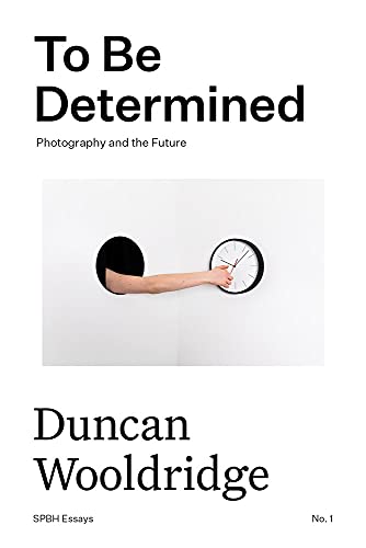 Book cover with an arm reaching through a wall holding a clock.