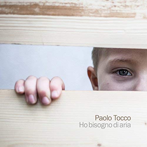 CD cover with a close-up of a person’s eye and hand framed by wood.