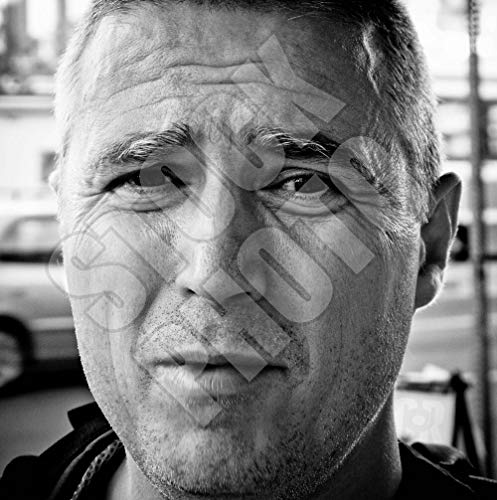 Black and white close-up portrait of a man with short hair.