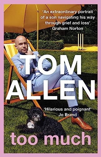 Tom Allen sits in a deckchair on a lawn with a small black dog.