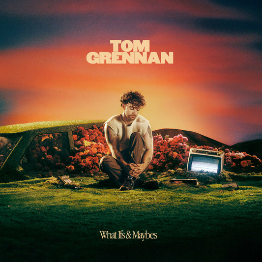 Tom Grennan album cover featuring the artist kneeling in a field with flowers and TV.