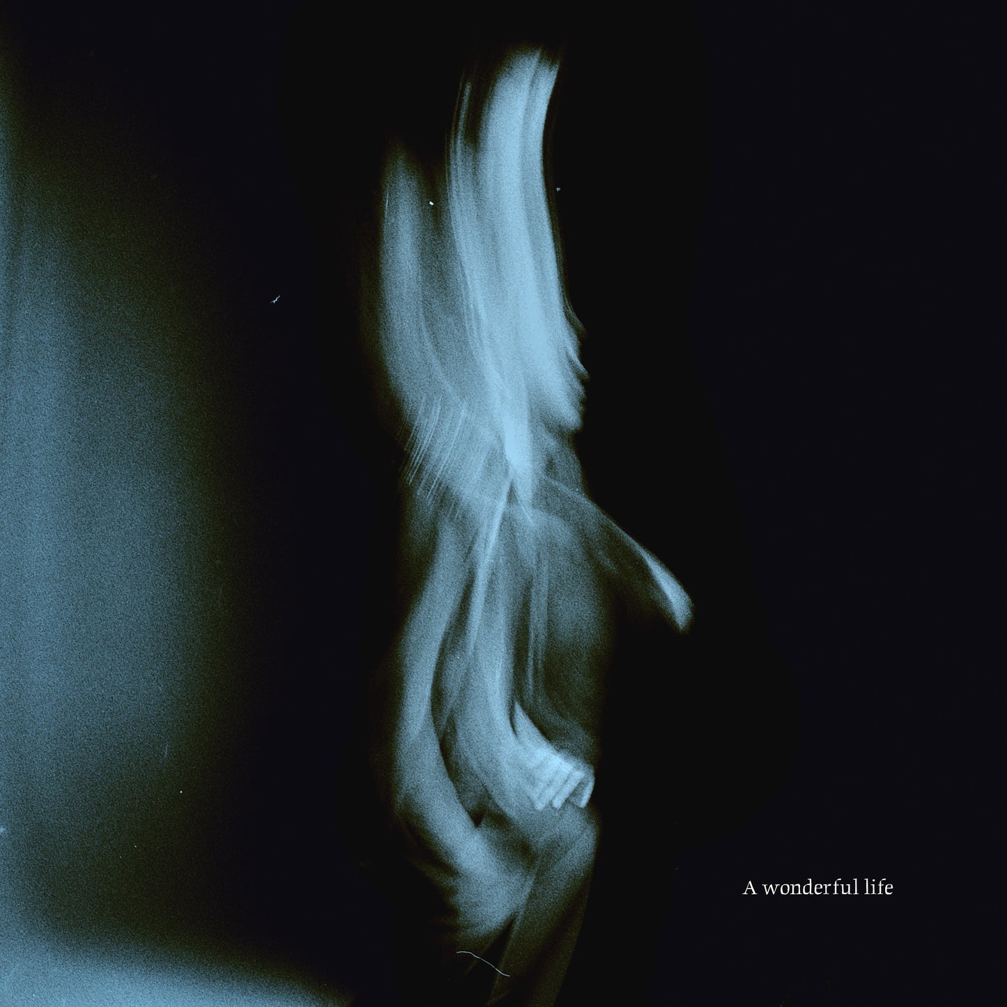 Blurred figure with flowing hair against a dark background, album cover.