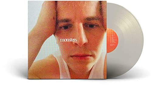 Tom Odell Monsters album cover featuring a close-up portrait with a silver vinyl disc.