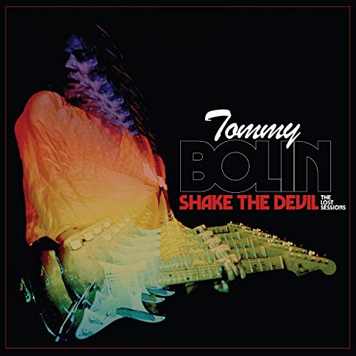 "Tommy Bolin's album cover featuring a man playing an electric guitar against a black background."