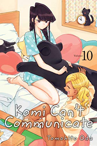Komi and Manbagi sit on a bed with a large black cat plush toy.