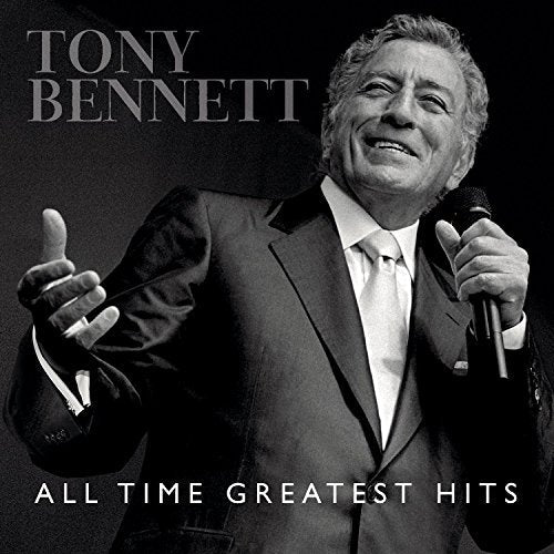 Black and white portrait of Tony Bennett in a suit singing into a microphone.