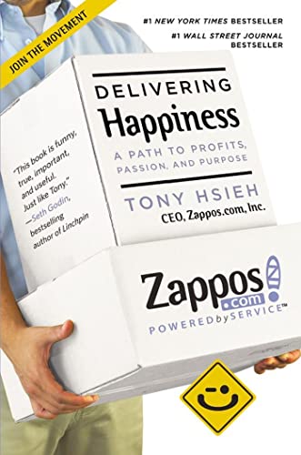Book cover for "Delivering Happiness" by Tony Hsieh, held by a person.