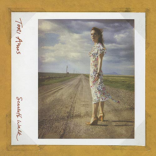 Tori Amos standing on a dirt road in a patterned dress, framed like a photo.