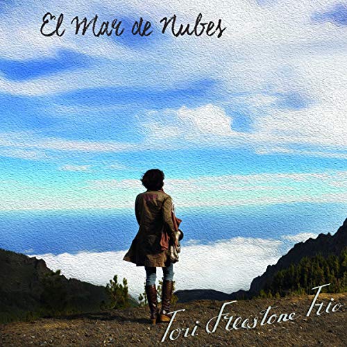 Album cover: woman overlooking a cloudy mountain landscape.