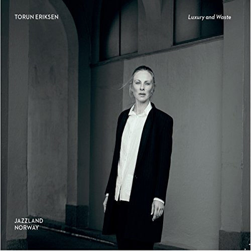 The album cover features a woman in a black suit and white shirt standing.