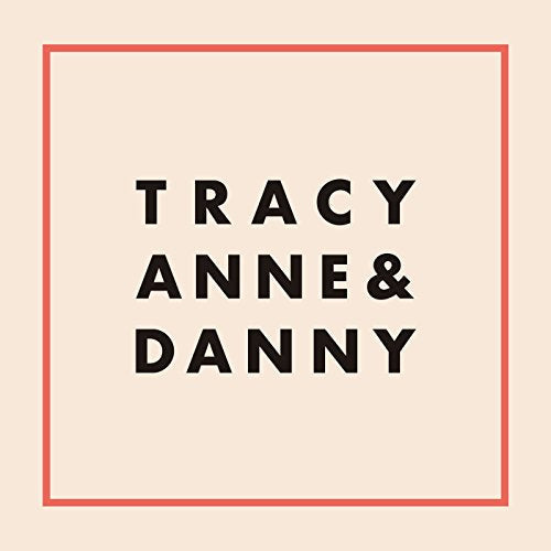 The image shows a pale peach square with a thin red border and black text inside. Alt text: Beige square with red border and "Tracy Anne & Danny" in black text.
