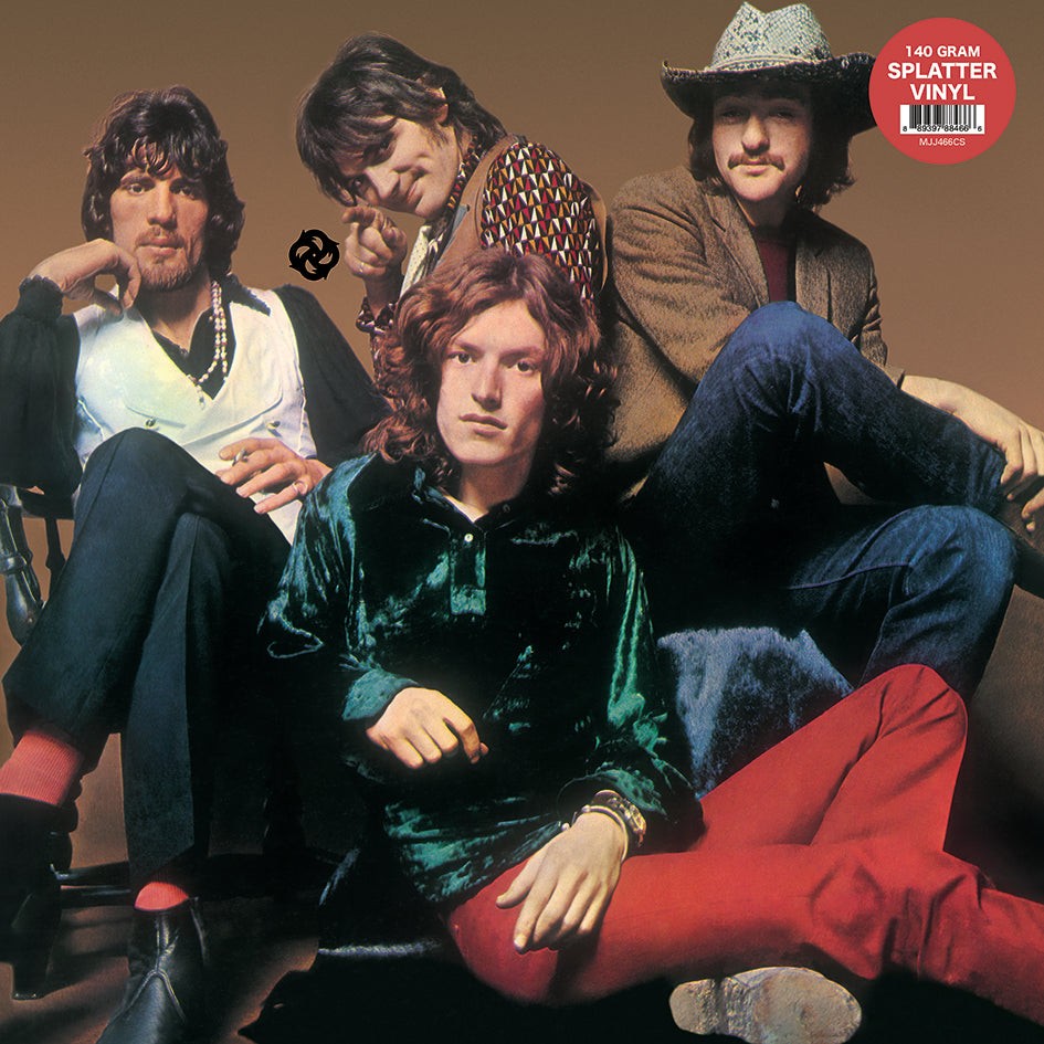 Four members of the band Traffic pose together against a plain brown background.