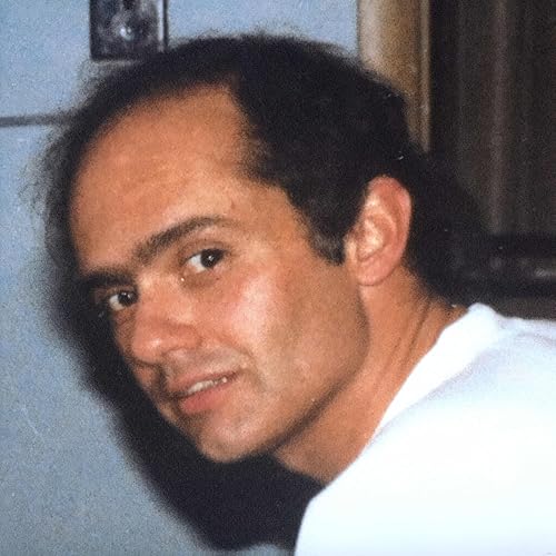 Close-up portrait of a man with dark hair looking toward the camera.