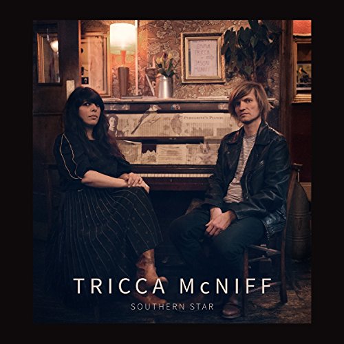 Album cover with two people sitting beside a piano, artist name and album title.