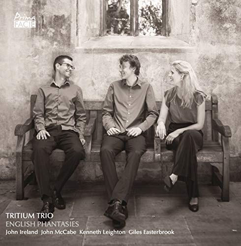 Black and white photo of three musicians seated on a wooden bench.