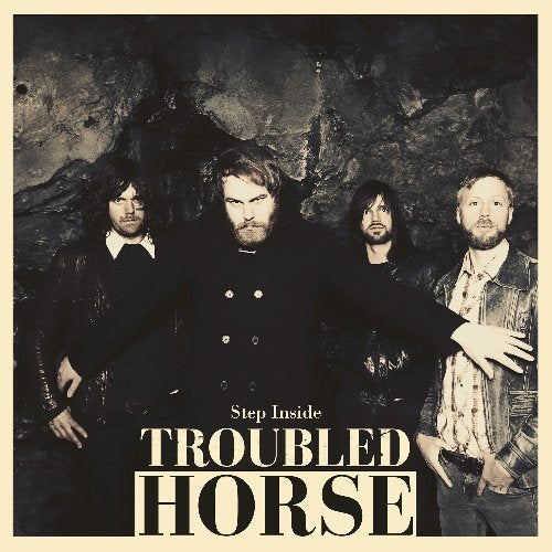 Troubled Horse band portrait in front of a dark, rocky background.