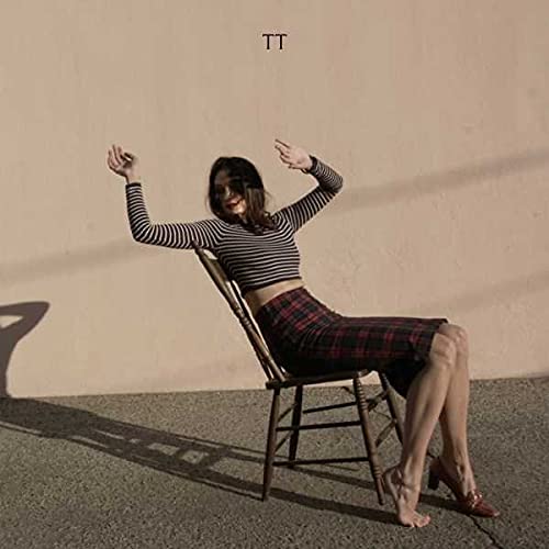 CD cover featuring a person in a striped top and plaid skirt on a chair.