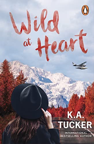 Book cover: mountains, airplane, woman with hat, red title "Wild at Heart".