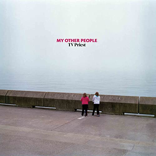 Album cover: two figures on a concrete seawall, pale sky.