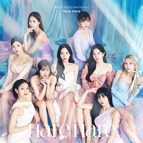 Nine women in pastel dresses pose against a cloudy blue background.