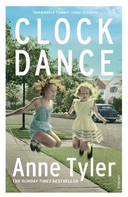 "Orange book cover with two young girls jumping on grass, author's name and title visible."