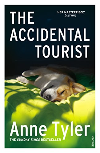 Book cover of "The Accidental Tourist" with a sleeping dog on yellow fabric.