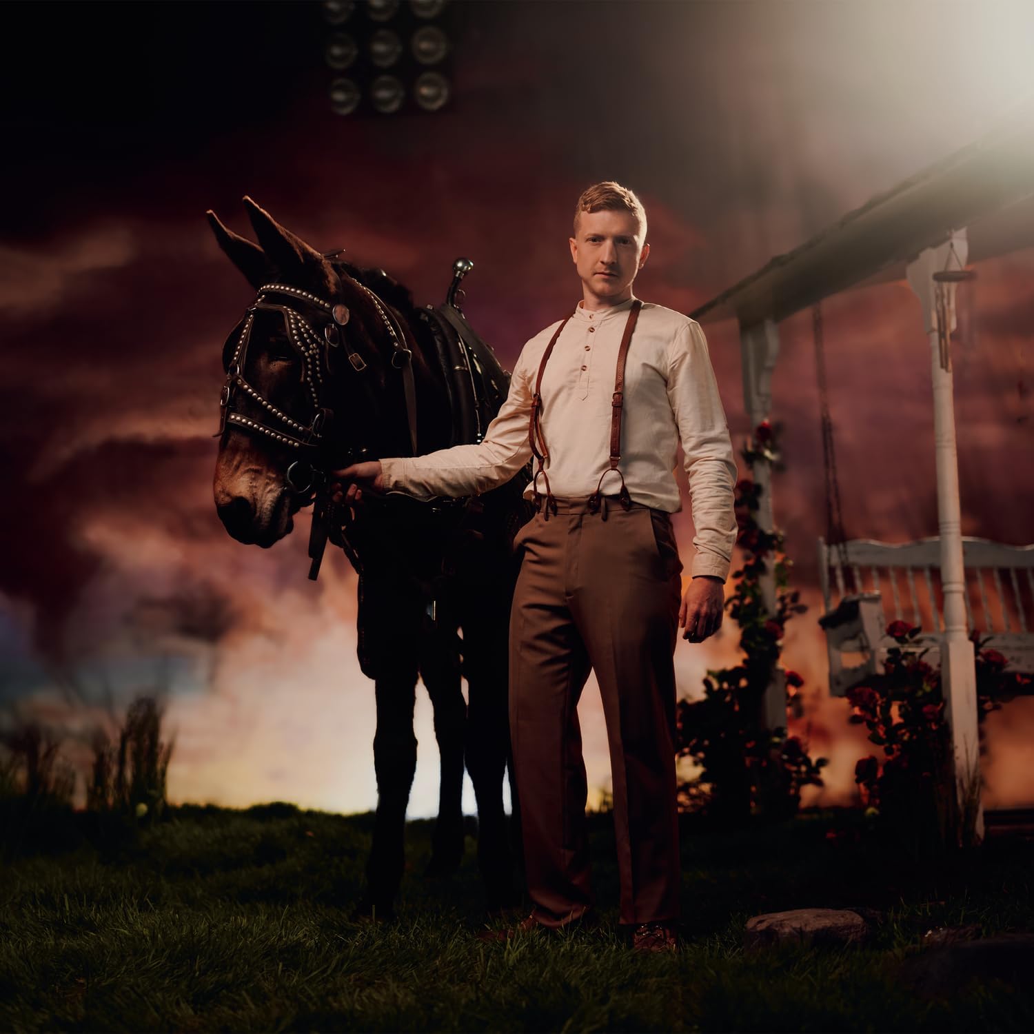 Tyler Childers stands with a mule in a rural, atmospheric setting.