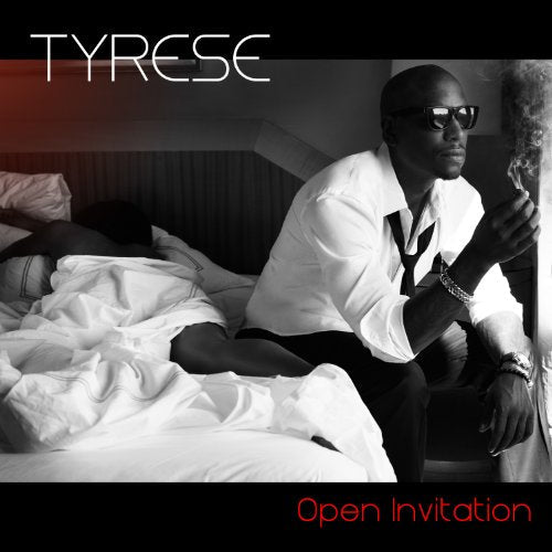 Tyrese wearing sunglasses and a white shirt sits on a bed holding a cigarette.