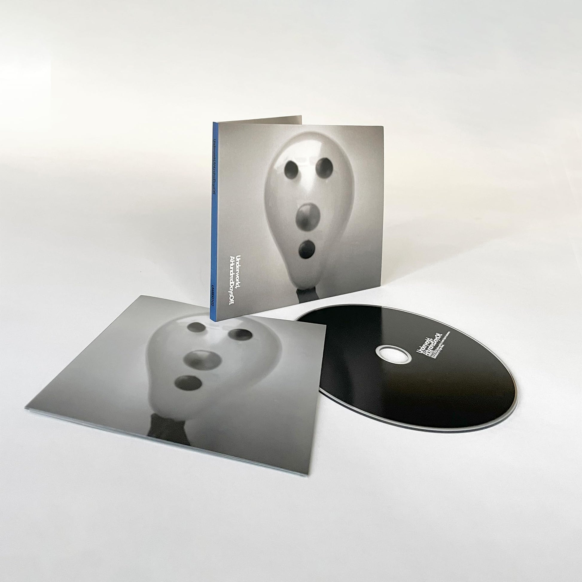 Underworld “A Hundred Days Off” reissue CD with abstract face cover art.